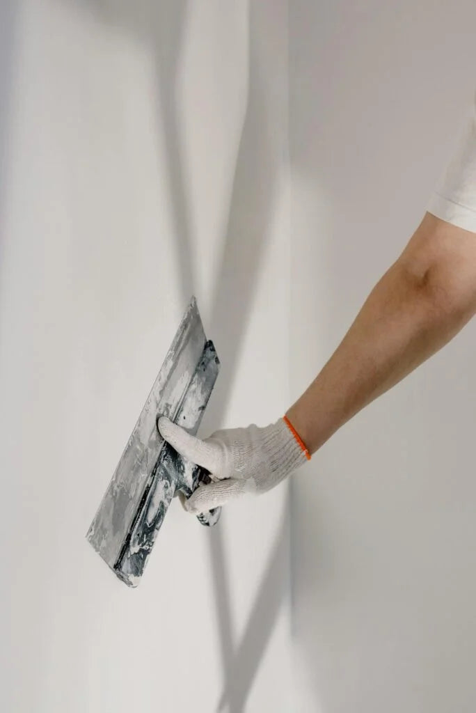 Plasterer finishing a wall with a trowel